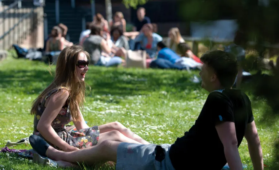 Postgraduate research students relaxing on the lawn