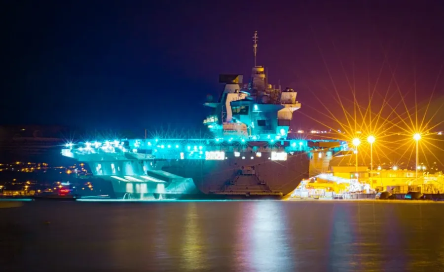 Night time image of a Queen Elizabeth Class Aircraft Carrier docked in Portsmouth Harbour