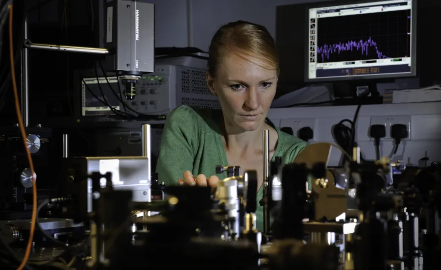 Professor Anna Peacock at work surrounded by equipment in the photonics lab