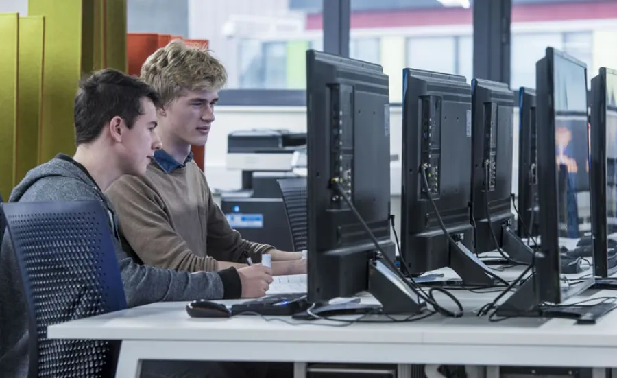 Two students working at a computer in the David Barron computing lab.