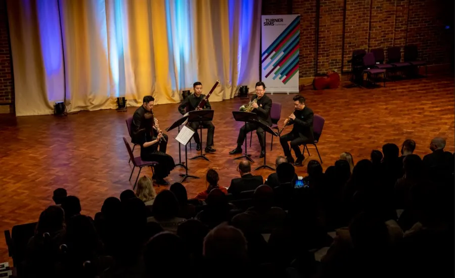A group of five musicians perform on stage at Turner Sims concert hall