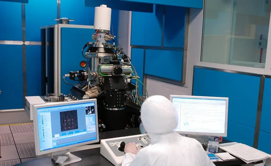 Man sat in a testing lab looking at nanofabrication helium ion microscope