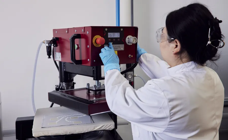 A woman researcher using a machine at the e-textile laboratory
