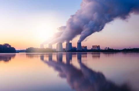 A landscape image of a coal-fired power station expelling pollution into the sky.