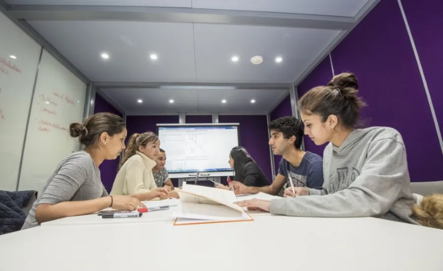 Group of students at work around a table in the maths student centre.