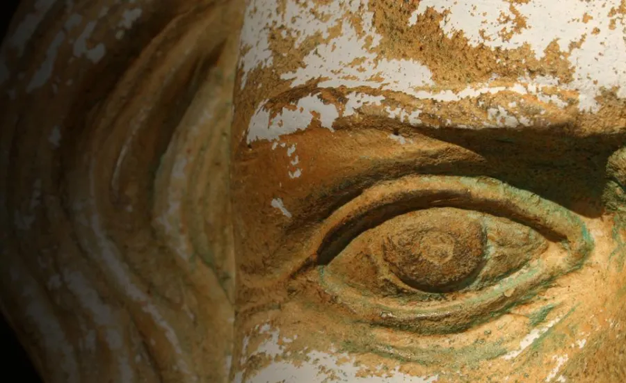 Close up of an ancient artefact face carved in stone